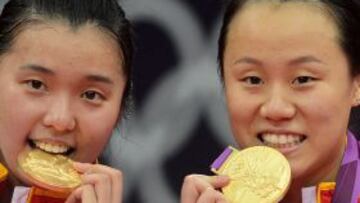 China's Tian Qing (L) and Zhao Yunlei celebrate with their gold medals after beating Japan's Mizuki Fuji and Reika Kakiiwa in the women's doubles badminton final match at the London 2012 Olympic Games in London, on August 4, 2012. AFP PHOTO / ADEK BERRY