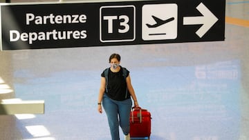 A passenger wearing a protective face mask walks at Fiumicino Airport on the day EU governments agreed a "safe list" of 14 countries for which they will allow non-essential travel starting from July, following the coronavirus disease (COVID-19)