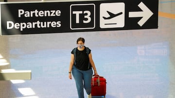 A passenger wearing a protective face mask walks at Fiumicino Airport on the day EU governments agreed a &quot;safe list&quot; of 14 countries for which they will allow non-essential travel starting from July, following the coronavirus disease (COVID-19) 