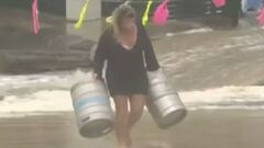 Chica con dos barriles de cerveza, uno en cada mano, salv&aacute;ndolos de las inundaciones. 