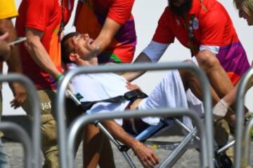 France's Yohann Diniz is helped by officials after competing in the Men's 50km Race Walk during the athletics event at the Rio 2016 Olympic Games in Pontal in Rio de Janeiro on August 19, 2016.   / AFP PHOTO / Jewel SAMAD