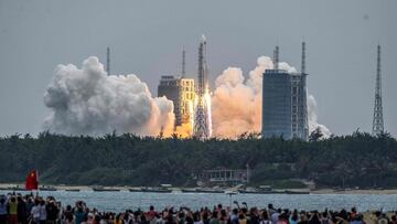 (FILES) In this file photo taken on April 29, 2021 People watch a Long March 5B rocket, carrying China's Tianhe space station core module, as it lifts off from the Wenchang Space Launch Center in southern China's Hainan province. - The Pentagon