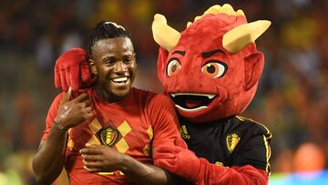 Batshuayi, objetivo del Atl&eacute;tico, celebra una victoria de B&eacute;lgica junto a la mascota.