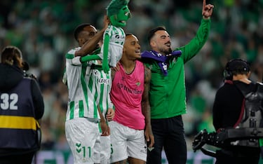 Los jugadores y aficionados del Betis, celebran la victoria ante el Sevilla tras finalizar el partido en el estadio Benito Villamarín.