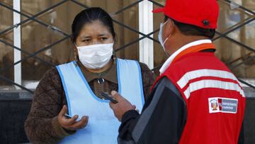 A woman is interviewed by staff of the Ministry of Women and Vulnerable Populations while holding a queue position outside a Pension Funds Administrator institution in the Andean city of Puno, close to the Bolivian border, to request information about the withdrawal of up to the equivalent of 1,080 US dollars in national currency from their pension funds to alleviate the crisis caused by the confinement in force for two months to combat the coronavirus on May 19, 2020. - A law published on April 30, authorizes members of the private pension system to &quot;voluntarily and extraordinarily, withdraw up to 25% of your total accumulated funds &quot;, up to a maximum of 3,700 Peruvian Soles per person. More than six million Peruvians can request the withdrawal which economists have warned will have &quot;long-term pernicious effectsx94. (Photo by Carlos MAMANI / AFP)