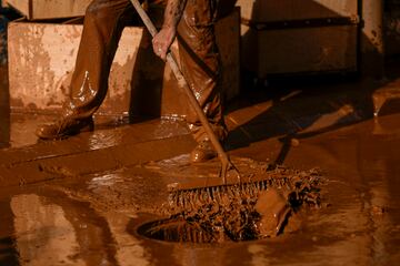 Una persona retira el barro tras las inundaciones en Utiel, España.