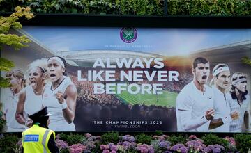 Una vigilante de seguridad observa en Londres un cartel publicitario de Wimbledon 2023, que comenzará el próximo lunes. Bajo el lema “Siempre como nunca antes”, llama la atención la imagen de Alcaraz junto a dos de los más grandes de la historia del tenis, Federer y Borg, para promocionar el torneo. Hay quien echa de menos a Djokovic en la foto. 