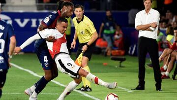 El delantero del Rayo, Ra&uacute;l de Tom&aacute;s (d), intenta controlar el bal&oacute;n ante el acoso del defensa portugu&eacute;s del Huesca, R&uacute;ben Semedo, durante el encuentro correspondiente a la tercera jornada de primera divisi&oacute;n disp