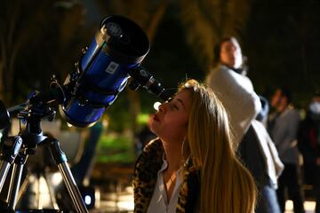 Una mujer mira a trav¨¦s de un telescopio en el techo del planetario distrital para ver un eclipse lunar en Bogot¨¢, Colombia