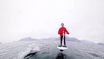 Jerry McArthur con el Hydroflyer y delfines rodeándolo.