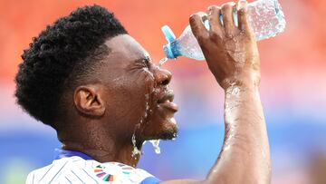 France's midfielder #08 Aurelien Tchouameni pours water on his face prior to the  UEFA Euro 2024 Group D football match between the Netherlands and France at the Leipzig Stadium in Leipzig on June 21, 2024. (Photo by FRANCK FIFE / AFP)