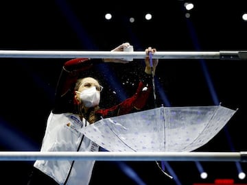 Una integrante del equipo alemán aplica magnesio sobre las barras asimétricas en el Campeonato de Europa de gimnasia artística, que tiene lugar en St. Jakobshalle, Basilea. Tan importante como asegurar el mejor agarre es no ensuciar la colchoneta, por lo que un paraguas invertido es ideal para recoger el magnesio sobrante.