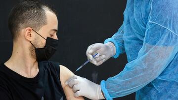 A nurse affiliated with the Palestinian ministry of health administers a COVID-19 vaccine to Palestinian citizens in the cultural center of Dura village, west of the West Bank city of Hebron, on August 2, 2021. (Photo by HAZEM BADER / AFP)
