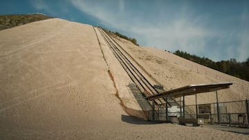 La pista de esquí de cuarzo de arena del Monte Kaolino (Bavaria, Alemania), vista desde abajo con el remonte a la derecha y el cielo con nubes altas.