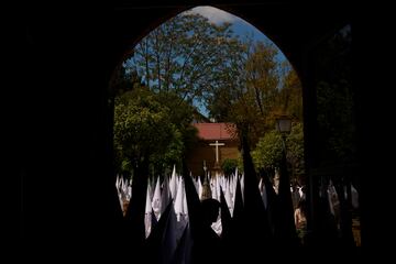 Penitentes de la Hermandad de la Paz participan en una procesión en Sevilla el Domingo de Ramos.
