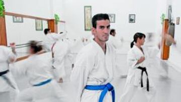 <b>INVITADO DE LUJO. </b>Alejandro Alfaro posa equipado en el gimnasio Vistabella. Mientras, a su espalda, los alumnos practican el ataque y la defensa del noble arte del kárate.