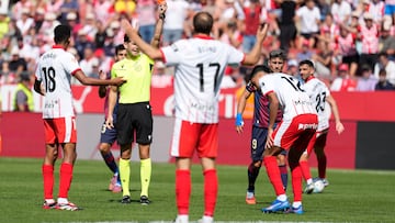 El defensa del Girona FC, Vitor Reis (d) ve la tarjeta roja durate el partido de LaLiga disputado este sábado en el estadio municipal de Montilivi en Girona. EFE/David Borrat
