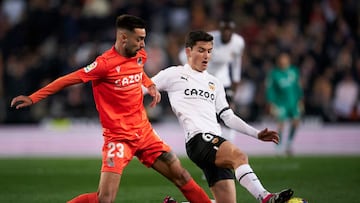 VALENCIA, SPAIN - FEBRUARY 25: Brais Mendez of Real Sociedad competes for the ball with Hugo Guillamon of Valencia CF during the LaLiga Santander match between Valencia CF and Real Sociedad at Estadio Mestalla on February 25, 2023 in Valencia, Spain. (Photo by Manuel Queimadelos/Quality Sport Images/Getty Images)