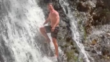 El actor australiano Chris Hemsworth, en bañador, en una cascada, a punto de practicar cliff diving.