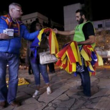 Un voluntario reparte esteladas en el acceso al Camp Nou.