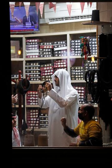 Un hombre se prueba un agal (cordón negro que sostiene el pañuelo utilizado para cubrir la cabeza) en una tienda del zoco.  