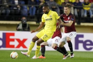 El delantero del Villarreal Cédric Bakambu y el centrocampista del Sparta Praga Lukas Marecek pelean un balón durante el partido de ida de cuartos de final de la Liga Europa que ambos equipos disputan en el estadio de El Madrigal.