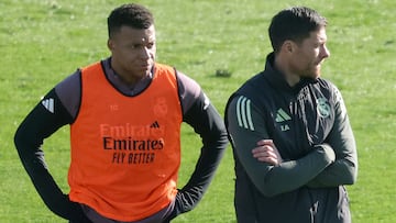 (FILES) Real Madrid's French forward #10 Kylian Mbappe (L) and Real Madrid's Spanish coach Xabi Alonso attend an open door training session at Real Madrid Sports City in Valdebebas, in the outskirts of Madrid, on December 30, 2025. Real Madrid's French forward, Kylian Mbappe, will be sidelined for at least three weeks due to discomfort in the lateral collateral ligament of one knee, a source close to the player told AFP on December 31, 2025. Real Madrid coach Xabi Alonso admitted on January 3, 2026, he does not know how long injured superstar Kylian Mbappe will be sidelined for. (Photo by Pierre-Philippe MARCOU / AFP)