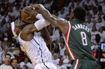 LeBron James de los Heat es taponado por Larry Sanders de los Bucks.