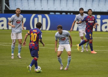 El jugador del Barcelona, Messi, controla el balón ante la defensa del Celta. 
