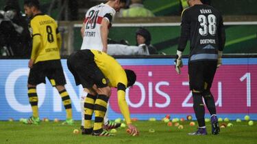 Los jugadores del Borussia recogen las pelotas lanzadas desde la grada.