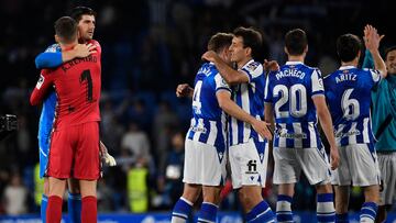 Real Madrid's Belgian goalkeeper Thibaut Courtois (L) hugs Real Sociedad's Spanish goalkeeper Alex Remiro as Real Sociedad players celebrate their win at the end of the Spanish league football match between Real Sociedad and Real Madrid CF at the Reale Arena stadium in San Sebastian on May 2, 2023. (Photo by ANDER GILLENEA / AFP)