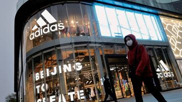 FILE PHOTO: People walk past an Adidas store in a shopping district following an outbreak of the coronavirus disease (COVID-19) in Beijing, China, April 5, 2021. REUTERS/Thomas Peter/File Photo