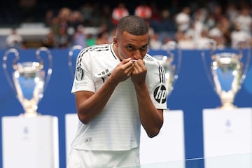 Mbappé kisses the Real Madrid badge during his unveiling. 