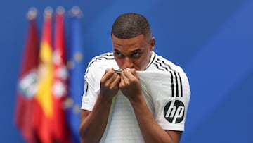 French forward Kylian Mbappe kisses his jersey during his first appearance as a Real Madrid player at the Santiago Bernabeu Stadium in Madrid on July 16, 2024, after signing his new five-season contract. Still celebrating Spain's Euro 2024 triumph, Real Madrid fans have even more to cheer this July 16, 2024, as French superstar Kylian Mbappe is officially presented to a packed-out Santiago Bernabeu stadium. (Photo by Pierre-Philippe MARCOU / AFP)