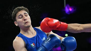 India's Nishant Dev (R) fights against Mexico's Marco Alonso Verde Alvarez in the men's 57kg quarter-final boxing match during the Paris 2024 Olympic Games at the North Paris Arena, in Villepinte on August 3, 2024. (Photo by MOHD RASFAN / AFP)