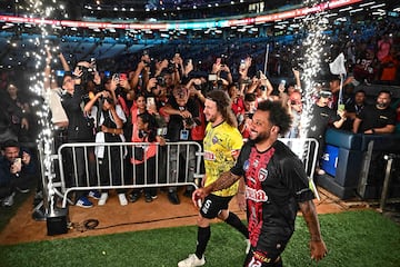 El exjugador del FC Barcelona Carles Puyol y el exmadridista Marcelo pasan sonrientes ante los numerosos medios de comunicación congregados en el Estadio Monumental Simón Bolívar de Caracas. Ambos estuvieron en la inauguración de la segunda edición de la Liga Monumental de Venezuela, representando a los equipos Cosa Nostra y Vergatarios FC.