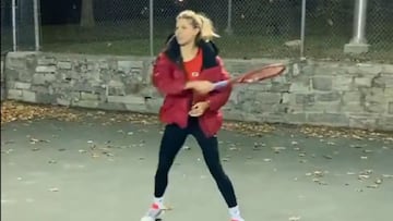 La tenista canadiense Eugenie Bouchard entrena con una chaqueta sobre una pista de tenis exterior en Canad&aacute;.