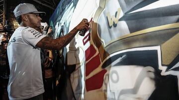 Lewis Hamilton pintando un casco en un acto en Brasil.