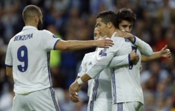 Real Madrid's Alvaro Morata, right, celebrates with Cristiano Ronaldo and Karim Benzema, left, after scoring his side's fifth goal during a Champions League, Group F soccer match between Real Madrid and Legia Warsaw, at the Santiago Bernabeu stadium in Ma