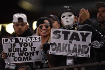 Dos fans de los Raiders sostienen sendos carteles durante el encuentro contra los Broncos. El de la derecha reza "Quedaos en Oakland". El de la izquierda pone "Ya sé que mi amigo da miedete porque va en plan Michael Myers, pero va, quedaos, que no hace nada".