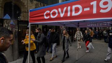 Pedestrians pass a covid-19 testing booth on a street in New York on December 6, 2021. (Photo by Ed JONES / AFP)