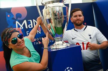 Football fans pose with the UEFA Champions League trophy after it was unveiled in Madrid on May 29, 2019 ahead of the final football match between Liverpool and Tottenham Hotspur on June 1. 