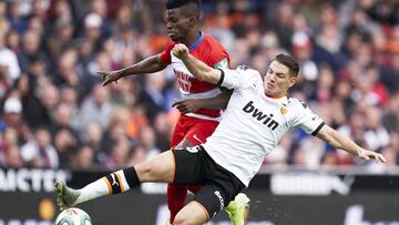 VALENCIA, SPAIN - NOVEMBER 09: Manu Vallejo of Valencia CF competes for the ball with Azeez of Granada CF during the La Liga match between Valencia CF and Granada CF at Estadio Mestalla on November 09, 2019 in Valencia, Spain. (Photo by Quality Sport Imag