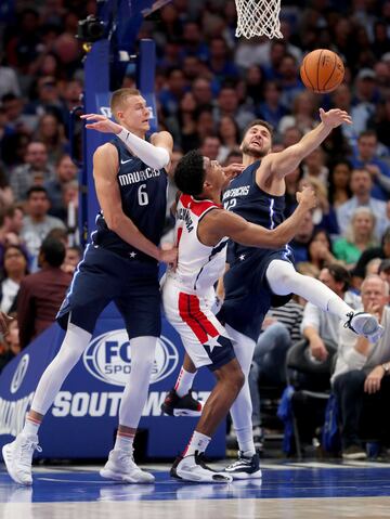 Rui Hachimura, Kristaps Porzingis y Kleber luchando por el balón. 