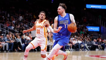 Luka Doncic #77 of the Dallas Mavericks drives to the basket against Trae Young #11 of the Atlanta Hawks.