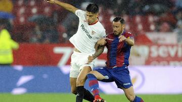 Sevilla's Argentinian midfielder Joaquin Correa (L) vies with Levante's Spanish defender Pedro Lopez during the Spanish league football match Sevilla FC vs Levante at the Ramon Sanchez Pizjuan stadium in Sevilla on December 15, 2017. / AFP PHOTO / Cristina Quicler
