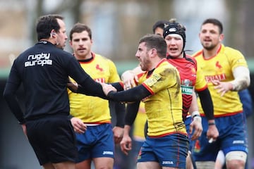 Spain players confront the referee after their defeat against Belgium.