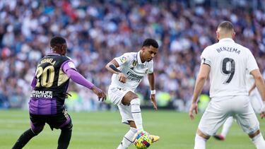 El centrocampista brasileño del Real Madrid, Rodrygo con el balón ante su compañero, Benzema (d) y el centrocampista del VAlladolid Martin Hongla (i) durante el partido de Liga que el Real Madrid y el Valladolid disputan este domingo en el estadio Santiago Bernabéu de Madrid.