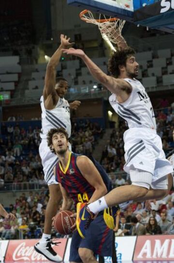 El pívot croata del FC Barcelona Ante Tomic (c) controla el balón ante los jugadores del Real Madrid, Sergio Llull (d) y el norteamericano Tremmell Darden.