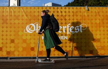 Una mujer conduce una scooter junto al logotipo del Oktoberfest, el día de la inauguración oficial.